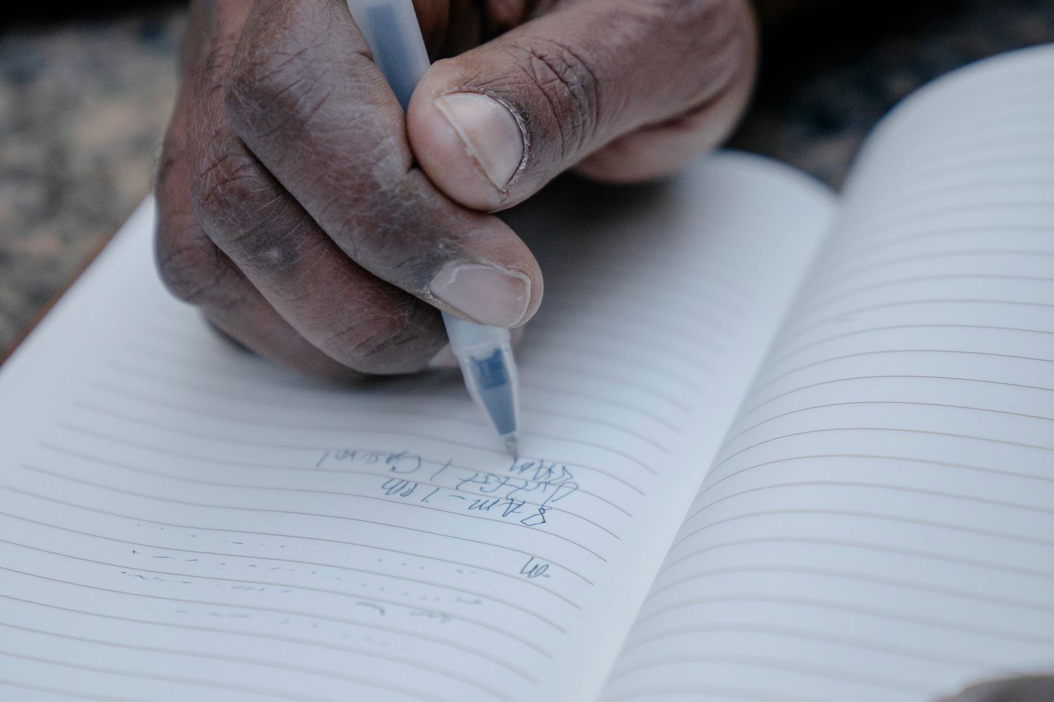 Mà d’una persona gran escrivint en una llibreta
